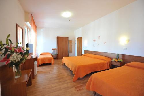 ein Hotelzimmer mit 2 Betten mit orangefarbener Bettwäsche in der Unterkunft Hotel Astor in Perugia