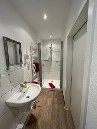 a white bathroom with a sink and a shower at Hotel Columbus und Glamping in Bremerhaven