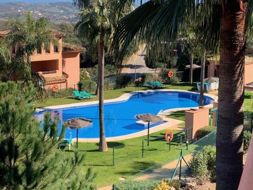 einen Pool in einem Resort mit Palmen in der Unterkunft El Soto de Marbella FREE Golf-Tennis-Spa Area 2 Bedroom Penthouse in La Mairena