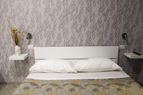 ローマにあるEufonia Vatican Daysの白いベッドが備わる壁のベッドルームです。