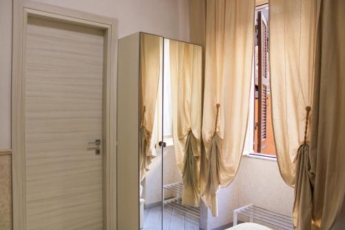 Un baño con ducha y una puerta con cortinas. en Eufonia Vatican Days, en Roma