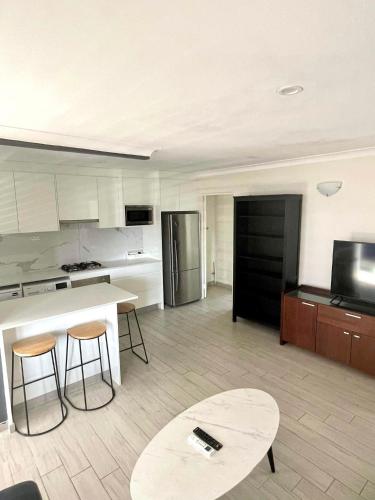 a kitchen with a counter and a table and chairs at Lotus Stay Manly - Apartment 31H in Sydney