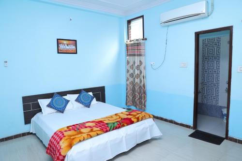 Hotel Marudhar Pushkar في بوشكار: غرفة نوم بسرير وجدار ازرق