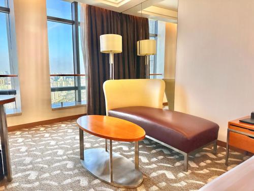 a hotel room with a chair and a table at Swissotel Foshan, Guangdong - Free shuttle to Canton Fair in Foshan