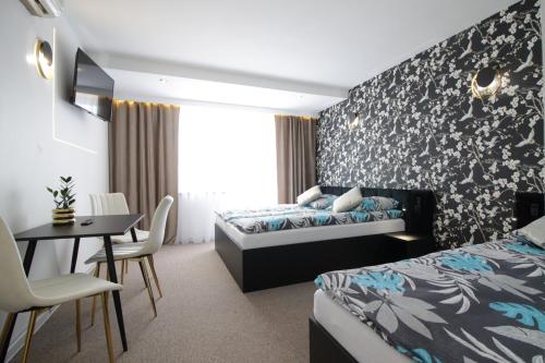 a hotel room with two beds and a table and chairs at Motel Na Zbójeckiej in Skawa