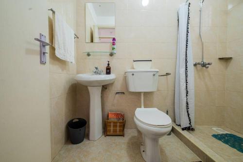 a bathroom with a toilet and a sink and a shower at The Hillpoint Nest in Nairobi