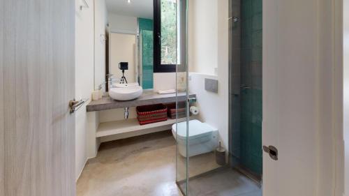 Villa Algarrobos في سانتا إيولاليا ديل ريو: حمام مع حوض ومرحاض ومرآة