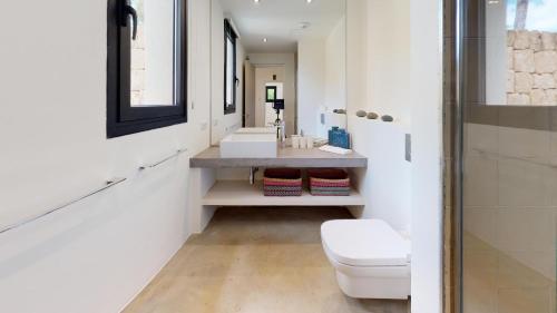 een badkamer met een wit toilet en een wastafel bij Villa Higueras in Santa Eularia des Riu