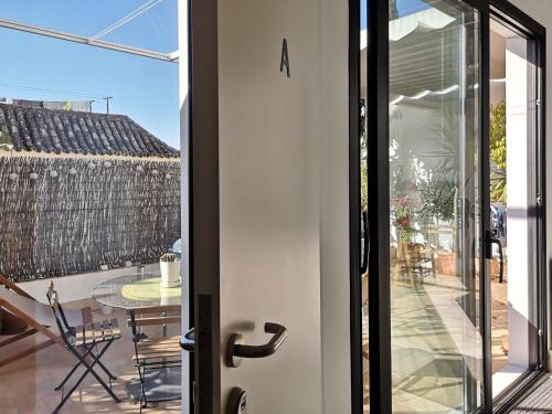 une porte en verre menant à une terrasse avec une table. dans l'établissement White Room Alameda, à Séville