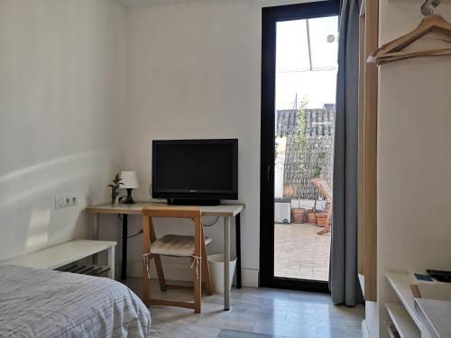 - une chambre avec un lit et une télévision sur un bureau dans l'établissement White Room Alameda, à Séville