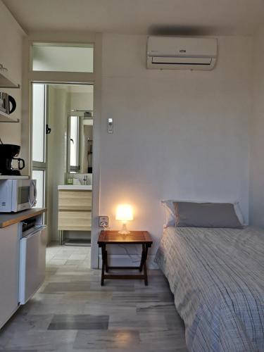 - une chambre avec un lit et une table avec une lampe dans l'établissement White Room Alameda, à Séville
