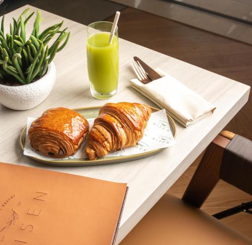 a table with a plate of croissants and a glass of orange juice at Wyndham Residences The Palm in Dubai