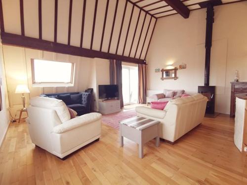 a living room with two white couches and a tv at Beach Retreat-3 Bed-Pet friendly-Central location in Trearddur