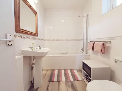 La salle de bains est pourvue d'un lavabo, d'une baignoire et de toilettes. dans l'établissement Wellington Court-3 Bed-Pet friendly-Beachfront, à Trearddur