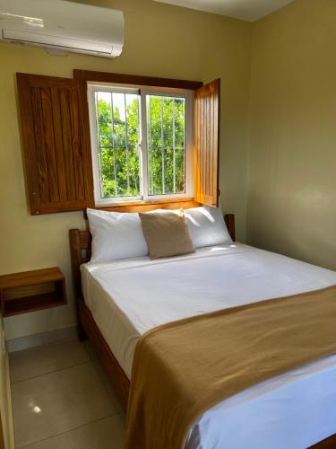 a bedroom with a large bed with a window at Hotel Yamilí in Punta Cana