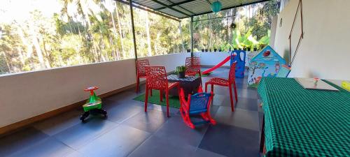a balcony with a table and chairs and a swing at ROBUSTA FOREST Home stay in Sultan Bathery