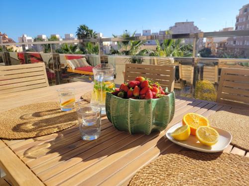 uma mesa com uma taça de fruta e uma taça de laranjas em Apartement Verano El Campello - 2 Bedrooms - Piscina - Garaje em El Campello