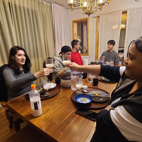 a group of people sitting around a table drinking wine at Batwo Stay - For foreigners only in Seoul