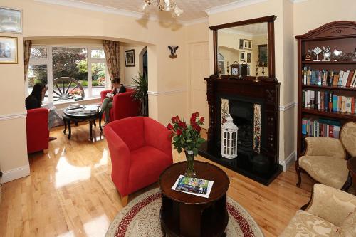 a living room with a red chair and a fireplace at Newtown Farm Country House in Ardmore