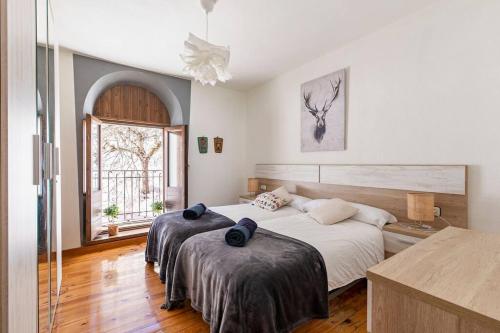 - une chambre avec 2 lits et une fenêtre dans l'établissement Espectacular apartamento reformado en edificio histórico, con WIFI, à Canfranc-Estación