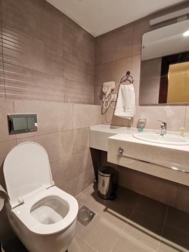 a bathroom with a toilet and a sink at Dara apartment hotel in Umm Uthainah