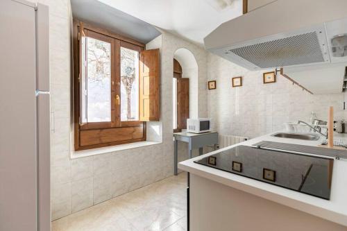 a white kitchen with a sink and a window at Espectacular apartamento reformado en edificio histórico, con WIFI in Canfranc-Estación