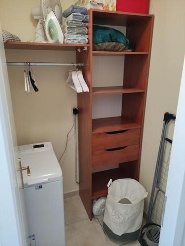 un placard avec une étagère en bois à côté des toilettes dans l'établissement Charmant T2 moderne au calme avec jardin vue sur Canigou, à Molitg-les-Bains