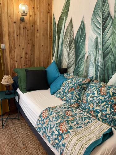 una camera con letto e parete con piante di L’anthurium a Saint-Paul