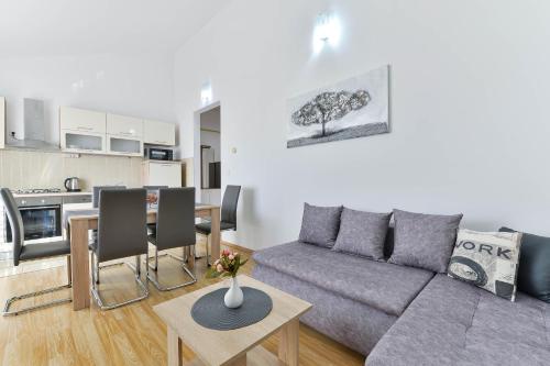 Il comprend un salon avec un canapé et une table. dans l'établissement Apartmani Stadion, à Zadar