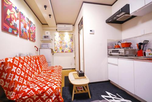 a living room with a couch and a kitchen at TOKYO ICHIBAN ASAKUSA in Tokyo