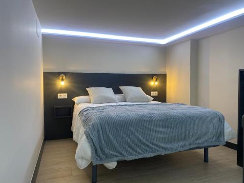 a bedroom with a large bed with two pillows at Loft 3 Ramon y Cajal Maracena in Maracena