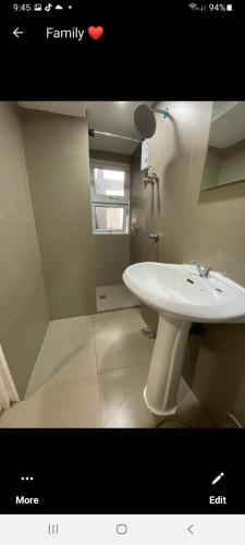 a bathroom with a white sink and a window at VICTORIA DE MAKATI Two (2) Bedroom Up and Down Condo in Manila