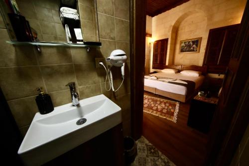a bathroom with a sink and a bedroom with a bed at Kaliruha Boutique Hotel in Urfa