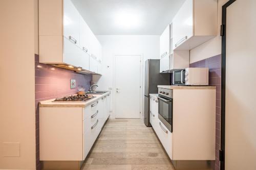 a kitchen with white cabinets and a stove at La Casa di Edo - WiFi Parking free in Modena