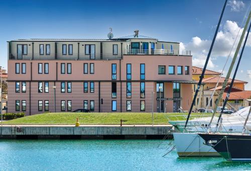 two boats docked in the water in front of a building at L'incanto Di Boccadarno in Marina di Pisa