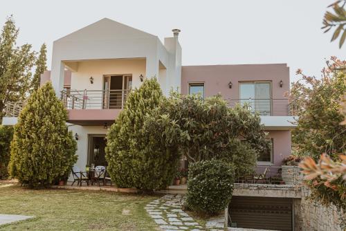 a pink house with trees in front of it at Villa Αρμονία στη φύση in Áno Kalésia