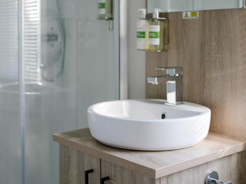 a bathroom with a white sink and a shower at St Mawgan's Cove 1 in Newquay