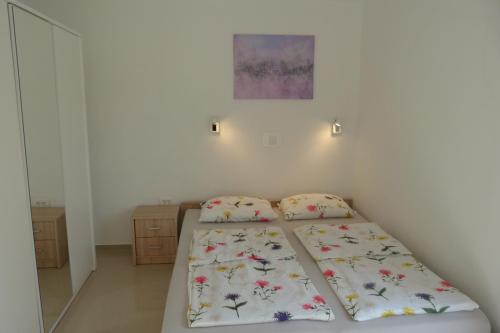 una piccola camera da letto con un letto e uno specchio di Apartments Monja & Dadi, Malinska, Vantačići a Vantačići