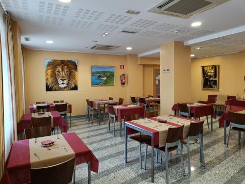 un restaurante con mesas y sillas y una pintura de un tigre en Hotel Palacio Congresos, en Palencia