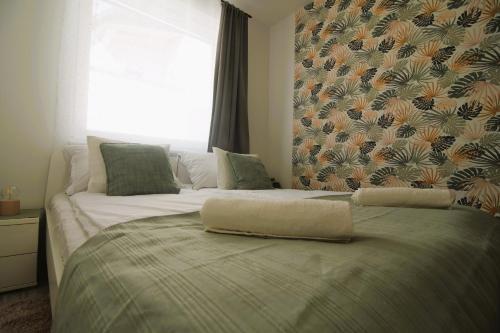 a bed with a pillow on top of it at Tisza River Apartman in Szeged