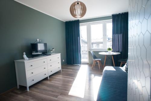 Schlafzimmer mit einem Bett, einem TV und einem Tisch in der Unterkunft Apartament Monte in Sopot