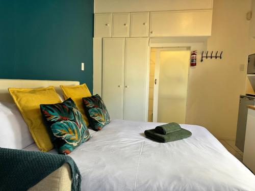 a hat sitting on top of a bed with pillows at Private Cottage on Alamein in Cape Town