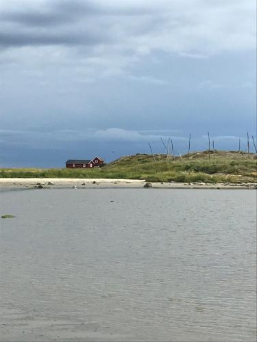uma casa numa colina ao lado de um corpo de água em Långasand em Heberg