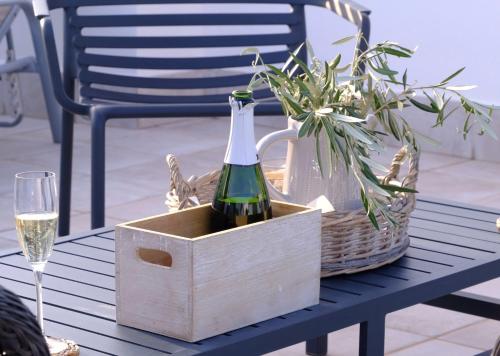 una bottiglia di vino in una scatola di legno su un tavolo con un bicchiere di Villa Tomillo a Málaga