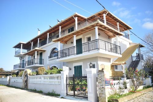 ein weißes Haus mit einem Zaun davor in der Unterkunft Villa Nefeli in Agios Georgios