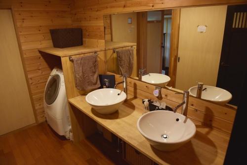 a bathroom with two sinks and a toilet at sabouしが in Matsumoto