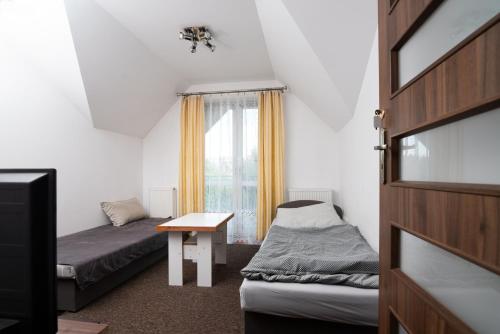 ein kleines Zimmer mit 2 Betten und einem Fenster in der Unterkunft Hubertus in Wola Rzędzińska