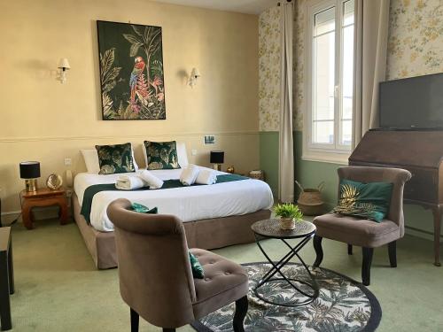 a hotel room with a bed and a piano at Hôtel de la Côte Fleurie in Deauville