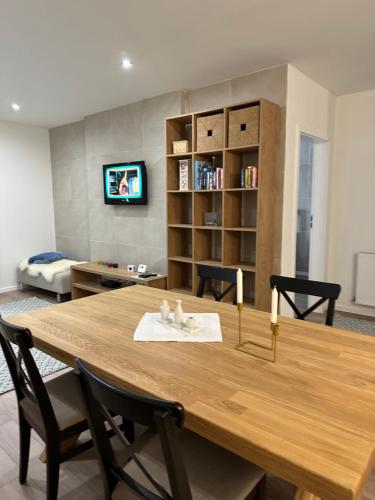 a dining room with a wooden table and a living room at SAND Apartment in Žilina