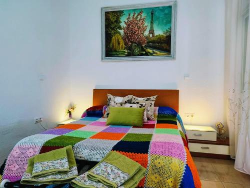 コルドバにあるApartamento La flor de Mayoのベッドルーム1室(カラフルな毛布付きのベッド1台付)